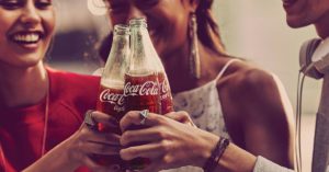 women sharing Cokes in an ad with Coca-Cola's iconic branding
